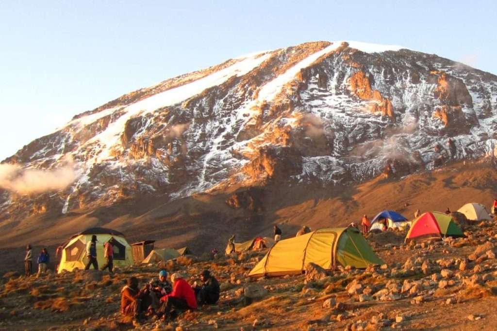 A scenic panoramic view of the 8-day Lemosho Route on Mount Kilimanjaro, showing the remote Shira Plateau and hikers approaching the snow-capped Uhuru Peak