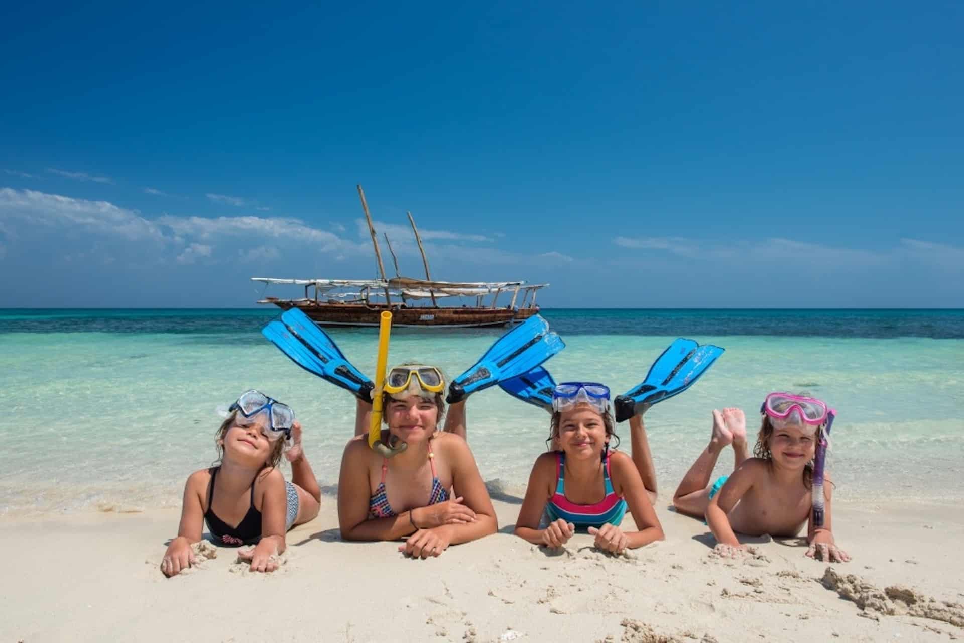 Family safari from Zanzibar enjoying a game drive in Tanzania with children watching elephants