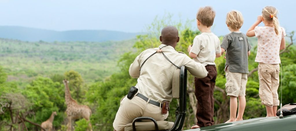 Family safari from Zanzibar enjoying a game drive in Tanzania with children watching elephants
