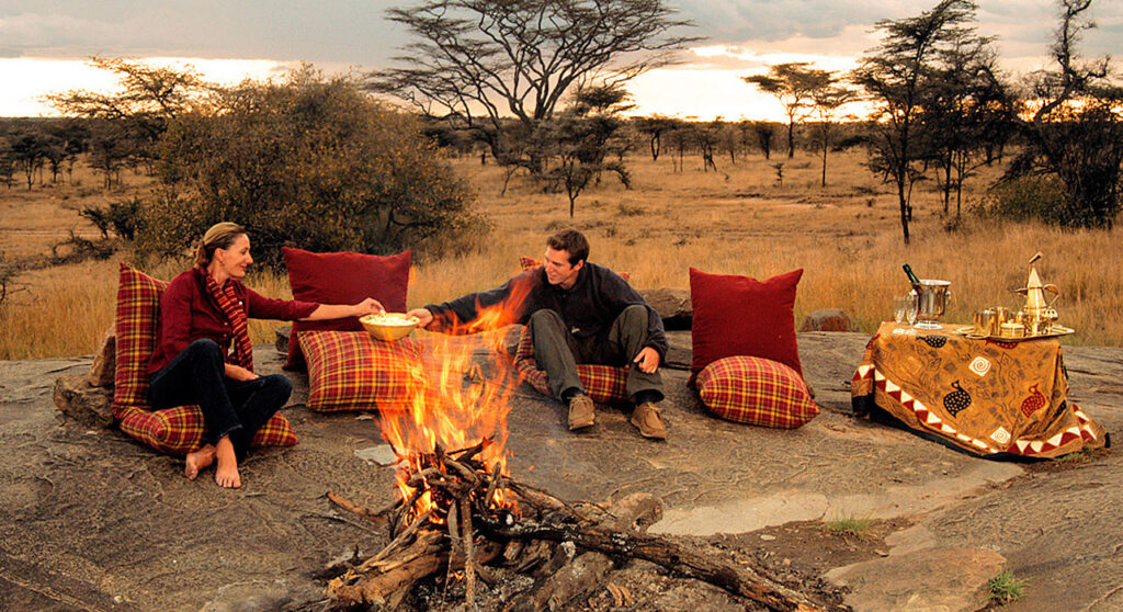 Tanzania honeymoon safari with couple watching Serengeti sunset